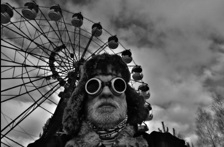 Autoritratto con occhiali davanti a una ruota panoramica, bianco e nero