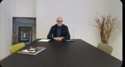 Andrea Schettin seduto a un tavolo durante una mostra